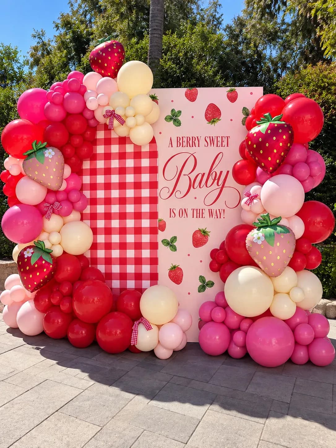 Decoración con globos para baby shower de fresas en Los Ángeles con fondo impreso personalizado, guirnalda orgánica rosa roja y crema, globos de fresa y detalles con lazos